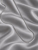 Vintage Mexican silver necklace arranged on soft satin fabric
