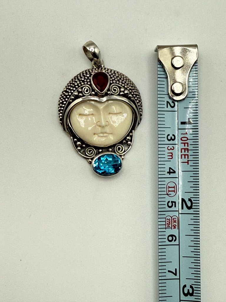 Vintage Balinese 925 silver face pendant beside measuring tape showing approximately 1.75 inch length