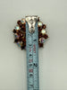 Vintage Aurora Borealis starburst brooch beside measuring tape showing approximately 1.5 inch width