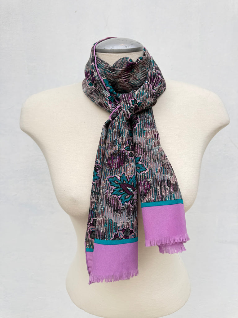 Long vintage Bill Blass silk scarf displayed on a mannequin with pink, teal, purple and grey floral details.