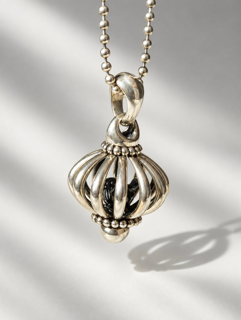 Close-up of LAGOS sterling silver birdcage pendant with sculptural bird detail
