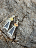 Back view of vintage black onyx earrings showing sterling silver posts and open-back settings