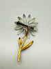 Back of vintage enamel daisy brooch showing gold tone metal stem and pin-back construction