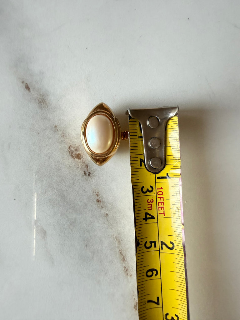 Vintage oval faux pearl jewellery clasp beside measuring tape for size