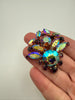 Close-up of vintage purple and aurora borealis rhinestone cluster brooch showing iridescent colour play