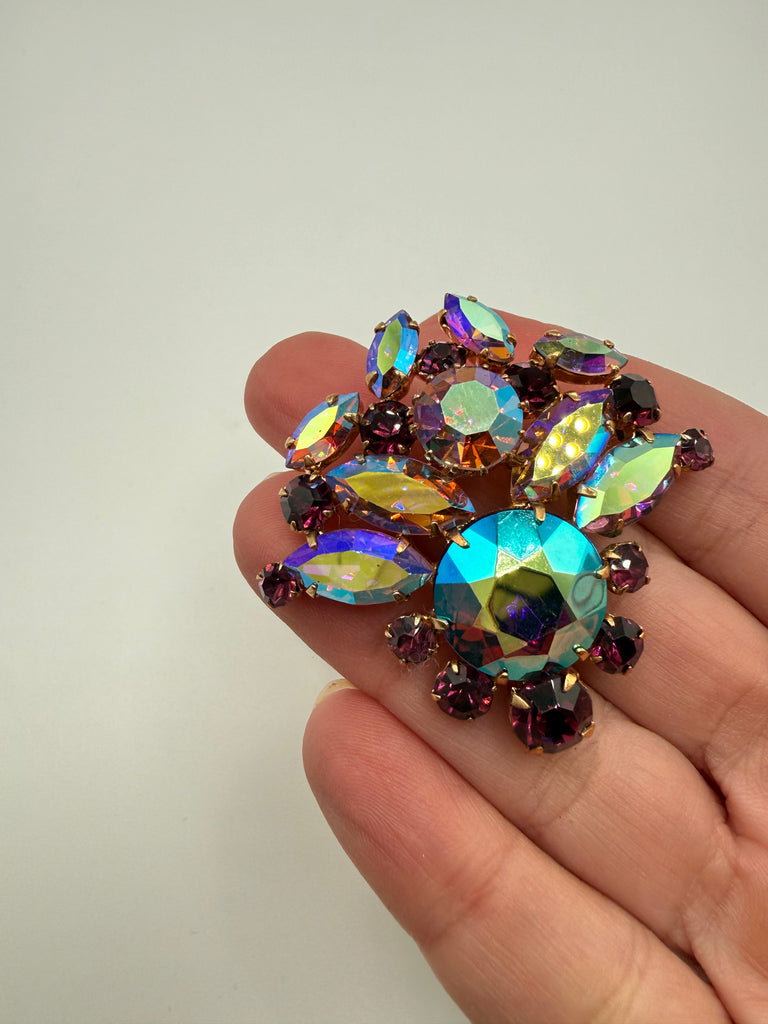 Close-up of vintage purple and aurora borealis rhinestone cluster brooch showing iridescent colour play