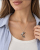 Silver dolphin pendant necklace worn with white blouse showing its size and drop