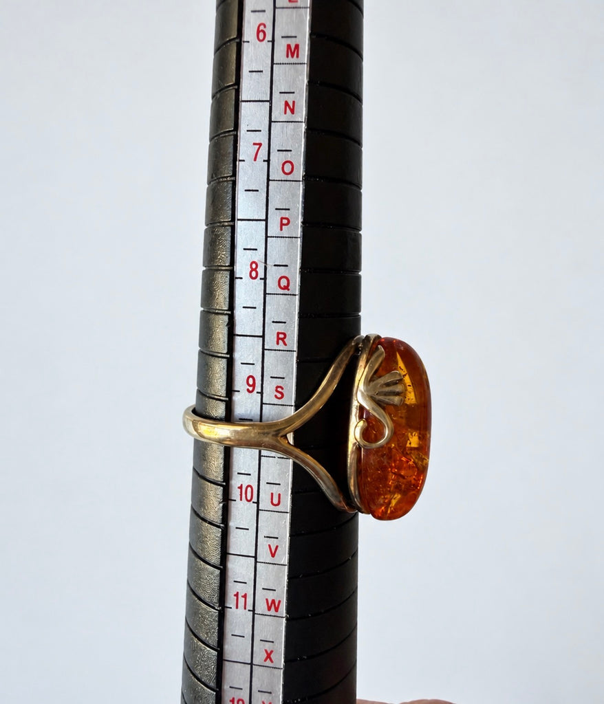 Gold-plated sterling silver amber ring on sizing mandrel showing ring size 9.5