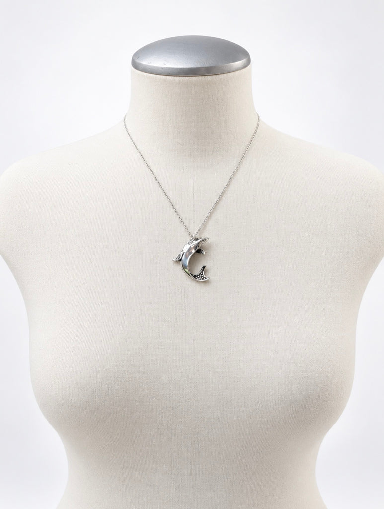 Vintage Ecco dolphin necklace displayed on white mannequin bust