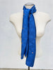 Long blue silk scarf styled draped around the neck on mannequin. 
