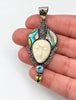 Vintage 925 silver face pendant with colourful abalone inlay shown in hand for scale