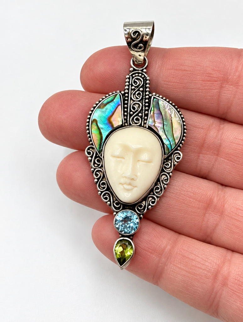 Vintage 925 silver face pendant with colourful abalone inlay shown in hand for scale