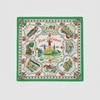 A square New Orleans-themed scarf laid flat on a textured concrete surface. The scarf features a white background with a vibrant green border, red roses, and multiple colorful illustrations of New Orleans landmarks including the Cathedral of Saint Louis, the Mississippi Riverboat, and the French Quarter, with 'New Orleans' written in red script in the center.
