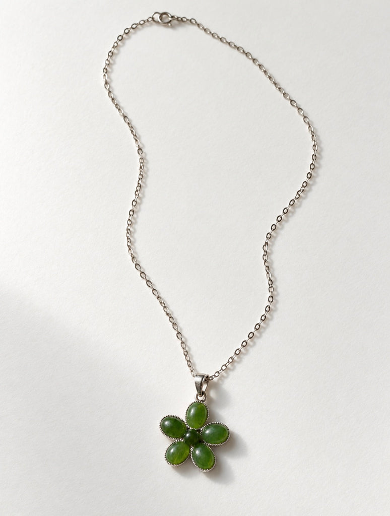 Sterling silver necklace laid flat with green jade floral pendant