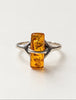 Front view of vintage cylindrical amber gemstone ring on white background