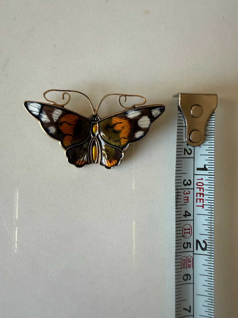 Vintage David-Andersen butterfly brooch beside measuring tape showing length