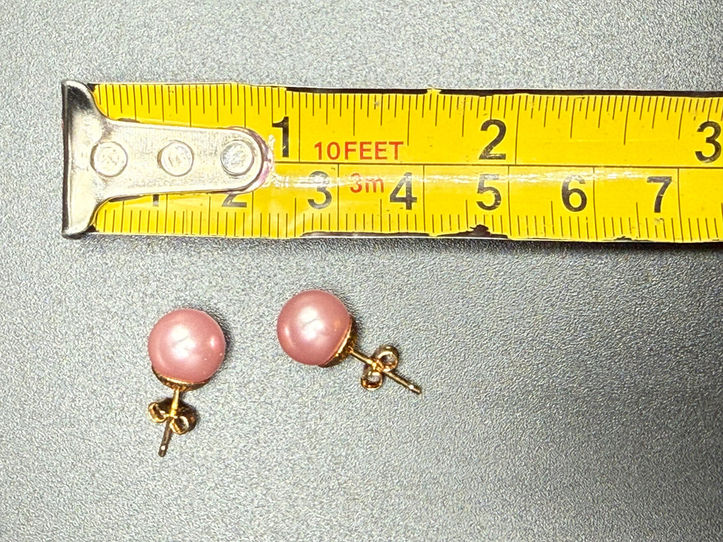 Vintage pink faux pearl stud earrings beside measuring tape showing approximately 10 mm diameter