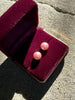 Pair of blush pink faux pearl stud earrings displayed in burgundy jewellery box