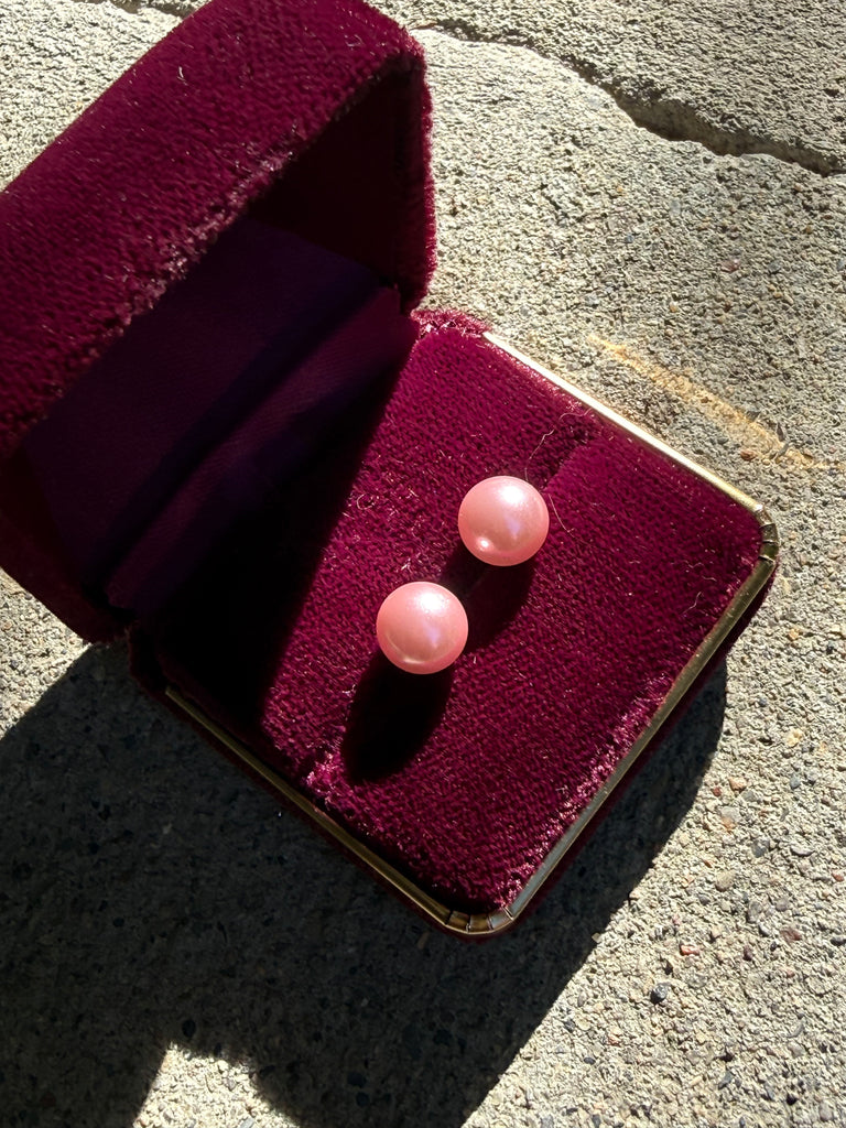 Pair of blush pink faux pearl stud earrings displayed in burgundy jewellery box
