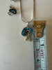 Turquoise mosaic pendant shown beside measuring tape for size