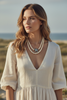 Heidi Daus starfish statement necklace worn with two strands of cream simulated pearls and Swarovski crystal pendant