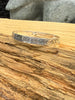 Close-up of Raven engraving and formline details on silver bracelet