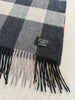 Close-up of V. Fraas cashmere scarf showing soft plaid fabric, fringed ends and tag