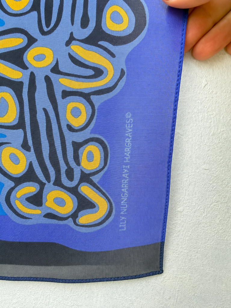 Detail of vintage Lily Nungarrayi Hargraves scarf showing artist signature and printed design. 
