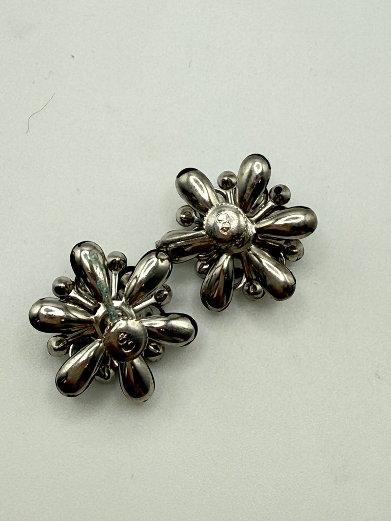 Vintage mid-century black flower earrings displayed together