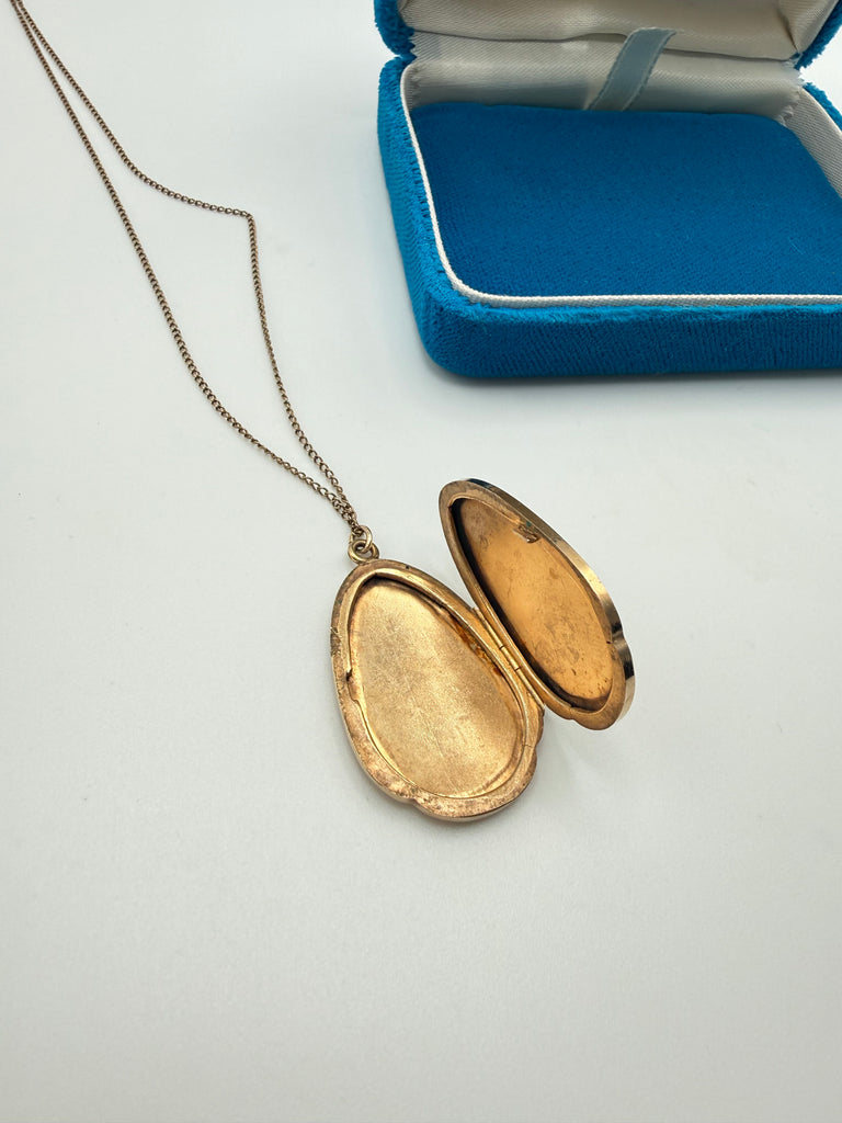 Vintage 1975 gold-filled photo locket shown open with two interior compartments