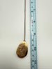 Vintage engraved gold-filled locket shown beside ruler for pendant measurement