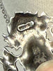 Reverse of vintage ECCO silver pendant showing maker's mark