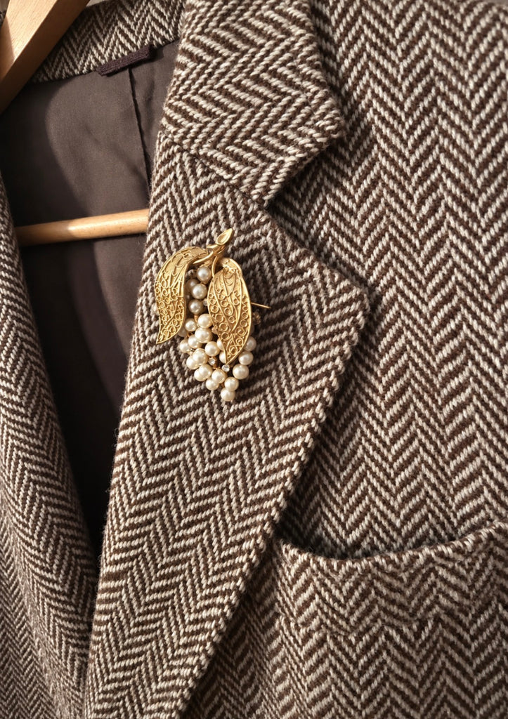 Vintage gold-tone grape brooch with cream faux pearls worn on blazer