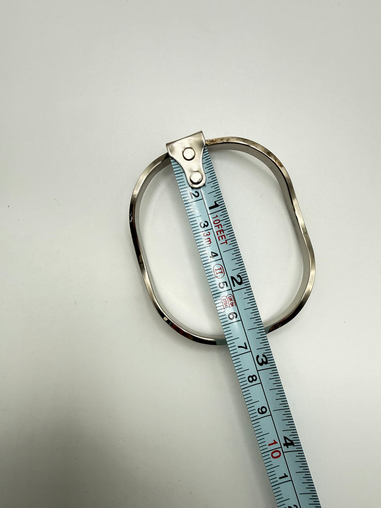 Vintage 925 silver bangle beside measuring tape showing bracelet dimensions