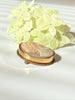 Side view of vintage shell cameo brooch pendant showing raised carved portrait