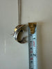 Sterling silver dolphin pendant photographed beside measuring tape