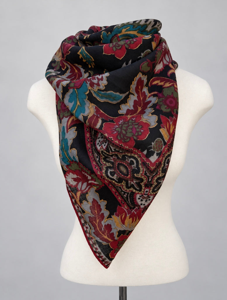Oversized wool paisley scarf folded into triangular neck scarf on mannequin