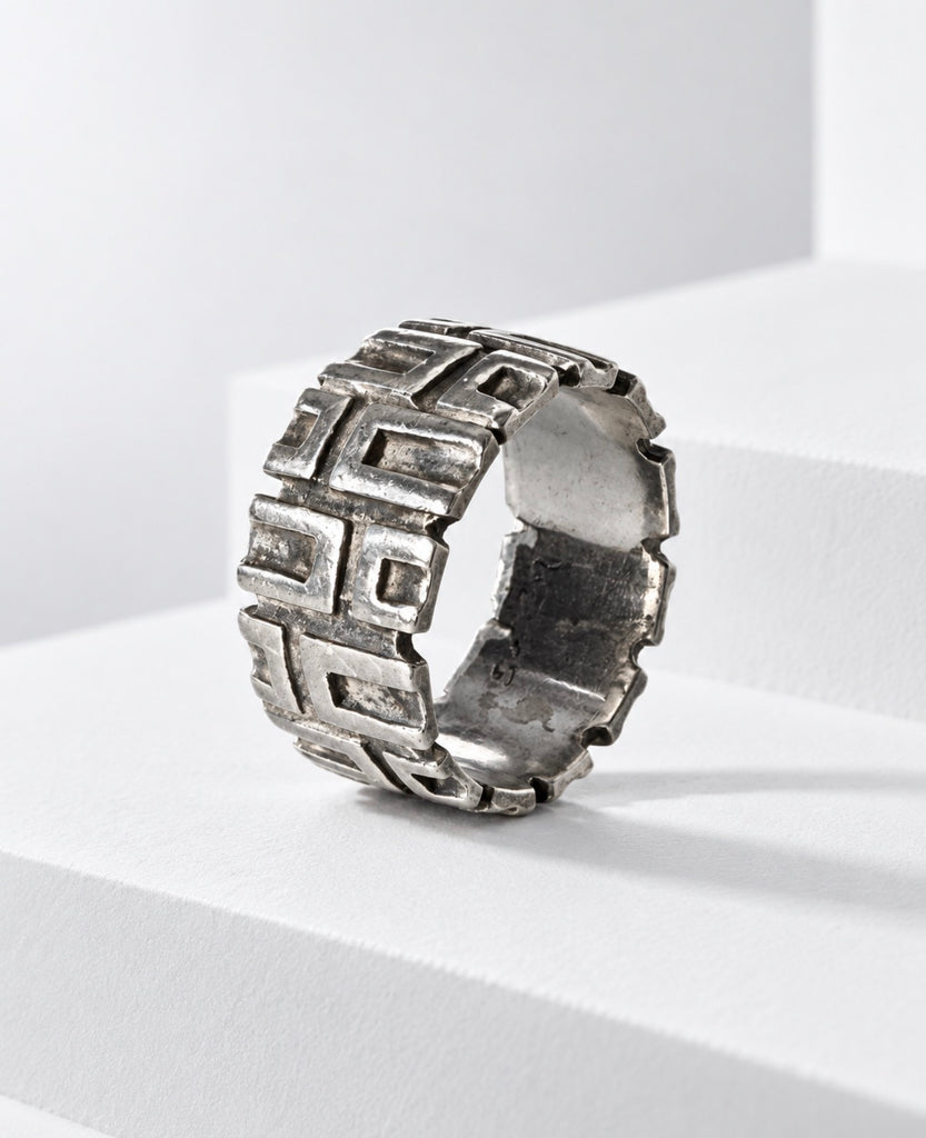Angled view of signed OPUS Brutalist sterling silver ring showing sculptural pattern