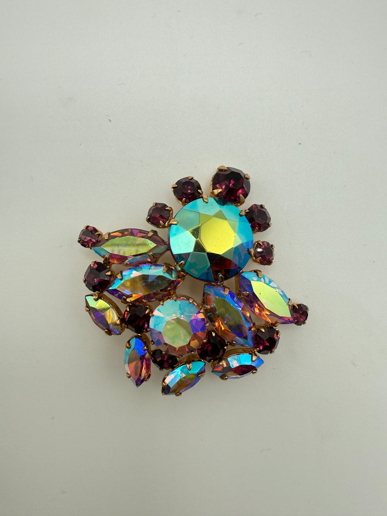 Front view of vintage AB rhinestone cluster brooch with purple round and marquise accent stones