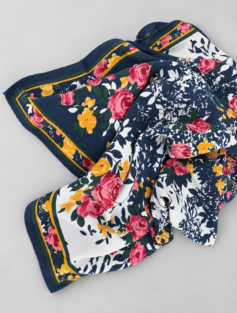 Vintage floral silk scarf folded to show navy border and colourful flowers