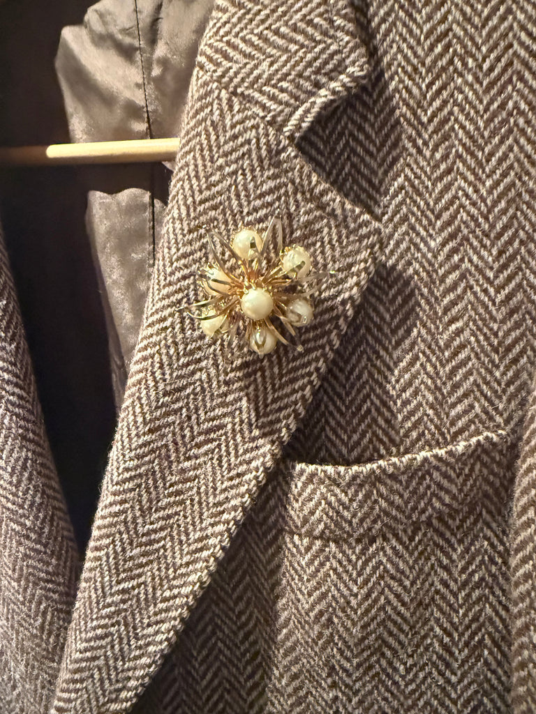 Vintage faux pearl floral starburst brooch worn on grey blazer