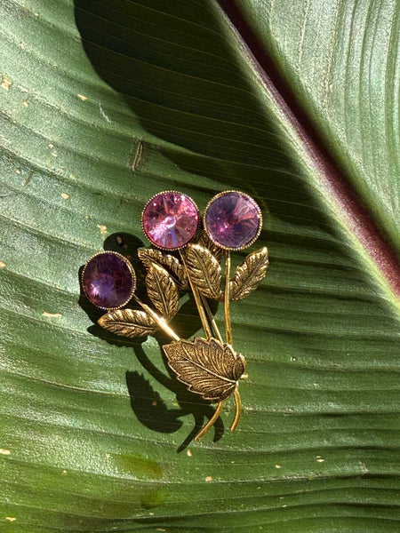 Vintage Austrian gold-tone floral brooch with pink and purple faceted crystals and textured leaves