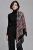 Woman wearing large Italian paisley scarf draped as a shawl over black outfit