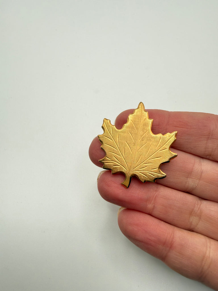 Vintage 1970 Canada maple leaf souvenir pin with textured gold-tone finish