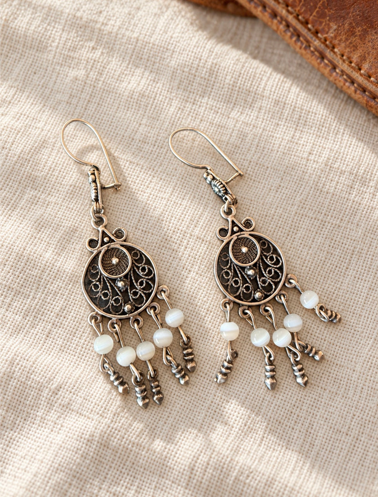 Pair of ornate sterling silver filigree dangle earrings displayed together