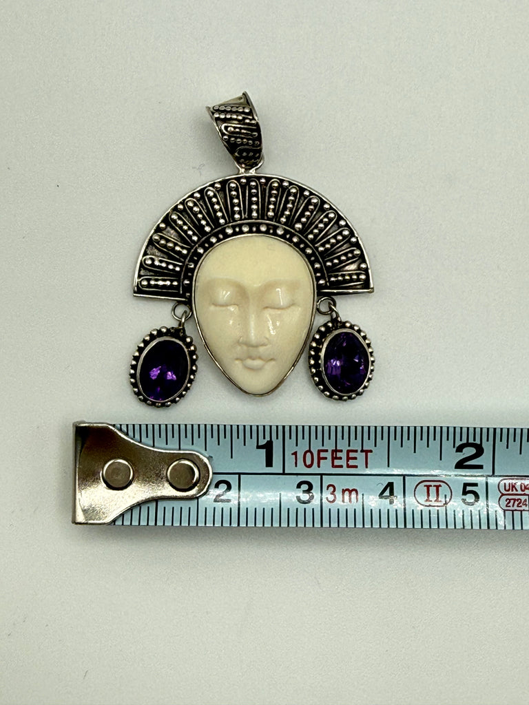 Vintage Balinese goddess sterling silver pendant beside measuring tape showing approximately 1.8 inch width