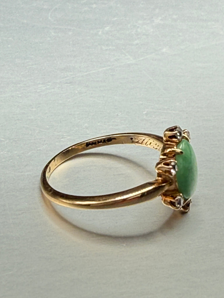 Side view of vintage 14K yellow gold ring showing raised green jade cabochon and diamond halo setting