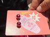 Dark pink faux pearl earrings on jewellery card