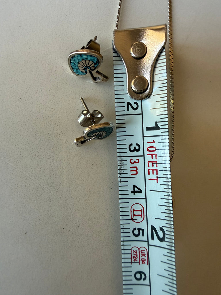 Vintage turquoise earring shown beside measuring tape for size
