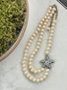 Full view of Heidi Daus Simply Irresistible double strand necklace with cream simulated pearls and bronze tone starfish pendant